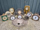 many different types of clocks sitting on the ground