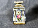 a small vase with a flower on it on a gray background