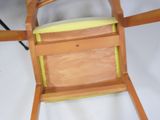 a wooden chair that has a yellow seat on it
