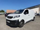 la camionnette blanche est garée dans un parking avec d'autres voitures