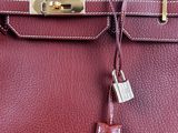 a close up of a red leather handbag with a lock on it