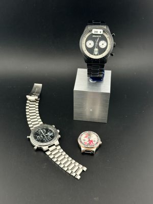 deux montres et un présentoir à montres posés sur une surface noire
