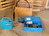 une boîte bleue équipée d'une pompe et un récipient bleu muni d'un tuyau