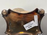 an antique brass plate with a label on it sitting on a table
