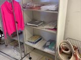 a closet with clothes and a basket on the floor