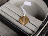 une médaille d'or dans un écrin noir posé sur une table noire