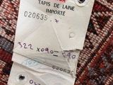 the label on the back of a red and white hat