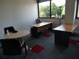 une photo d'un bureau vide avec une table et des chaises