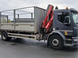 un camion équipé d'une grue à l'arrière, dans un parking