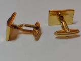 pair of gold plated cufflinks on a white surface