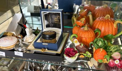 une vitrine en verre sur laquelle sont disposés divers objets décoratifs
