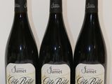 trois bouteilles de vin sont alignées sur une table