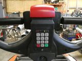 a close up of a red and black machine in a garage