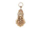 a close up of a gold plated pendant with a flower design