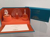 a glass display case with two bottles of perfume in it