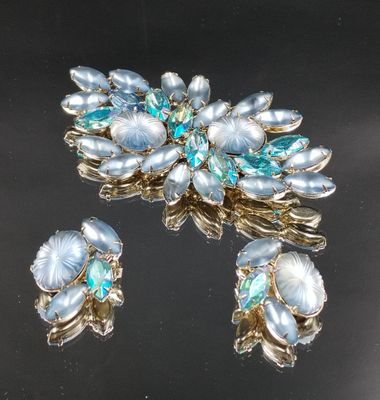 two pieces of jewelry sitting on top of a black surface