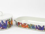 two white dishes with colorful floral designs on them on a white surface