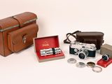 un sac en cuir marron sur lequel sont posés un appareil photo et d'autres objets