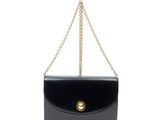 un sac à main noir avec un fermoir et une chaîne dorés