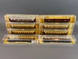 quatre trains miniatures dans des boîtes en plastique posés sur une surface grise