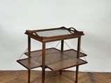 a wooden and glass serving cart on a parquet floor