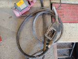 a hose that is sitting on the ground next to a piece of metal