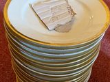 a stack of plates sitting on the floor in front of a chair