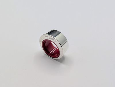 a close up of a red ring on a white surface