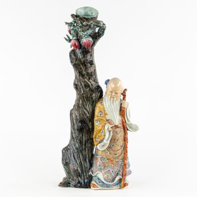 an oriental figurine of a man with a dragon on his arm