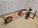 un petit chariot rouge à deux roues posé par terre