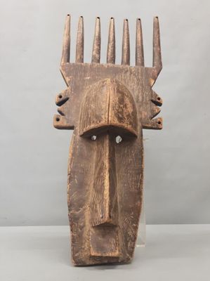 a close up of a wooden mask on a table