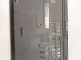 the laptop is sitting on a white surface with a small amount of screws
