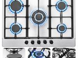 quatre brûleurs sur une cuisinière à gaz avec des flammes bleues