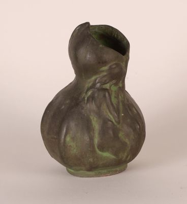 a green vase that is sitting on a white surface