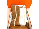 une boîte orange contenant une paire de bottes marron