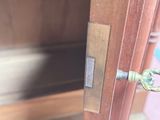 a close up of a door handle on a wooden cabinet