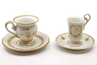 two cups and saucers sitting on a white table