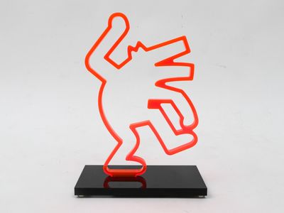 an orange neon sculpture of a man holding a knife on top of a black base