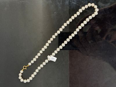 un collier de perles avec un fermoir en or et un collier de perles blanches avec un fermoir en or et un collier de perles blanches avec une perle blanche