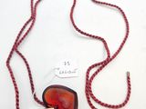 un gros plan d'un collier orné d'un cœur rouge