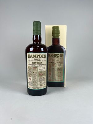 deux bouteilles de rhum vieilli Hampdie devant une boîte