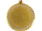 a close up of a gold pendant on a white background
