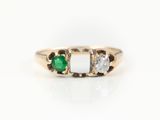 vue rapprochée d'une bague à trois pierres avec une pierre verte et une pierre blanche