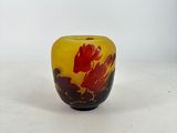 a yellow and red vase sitting on a white surface