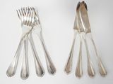 four forks and a spoon on a white surface