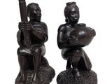 pair of african figurines of a man and a woman holding instruments