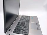 a silver laptop with a black keyboard on a white surface