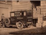 an old photo of a delivery truck parked in front of a building