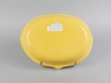a close up of a yellow plate on a gray surface