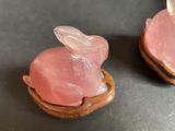 two pieces of pink quartz sitting on top of a piece of wood